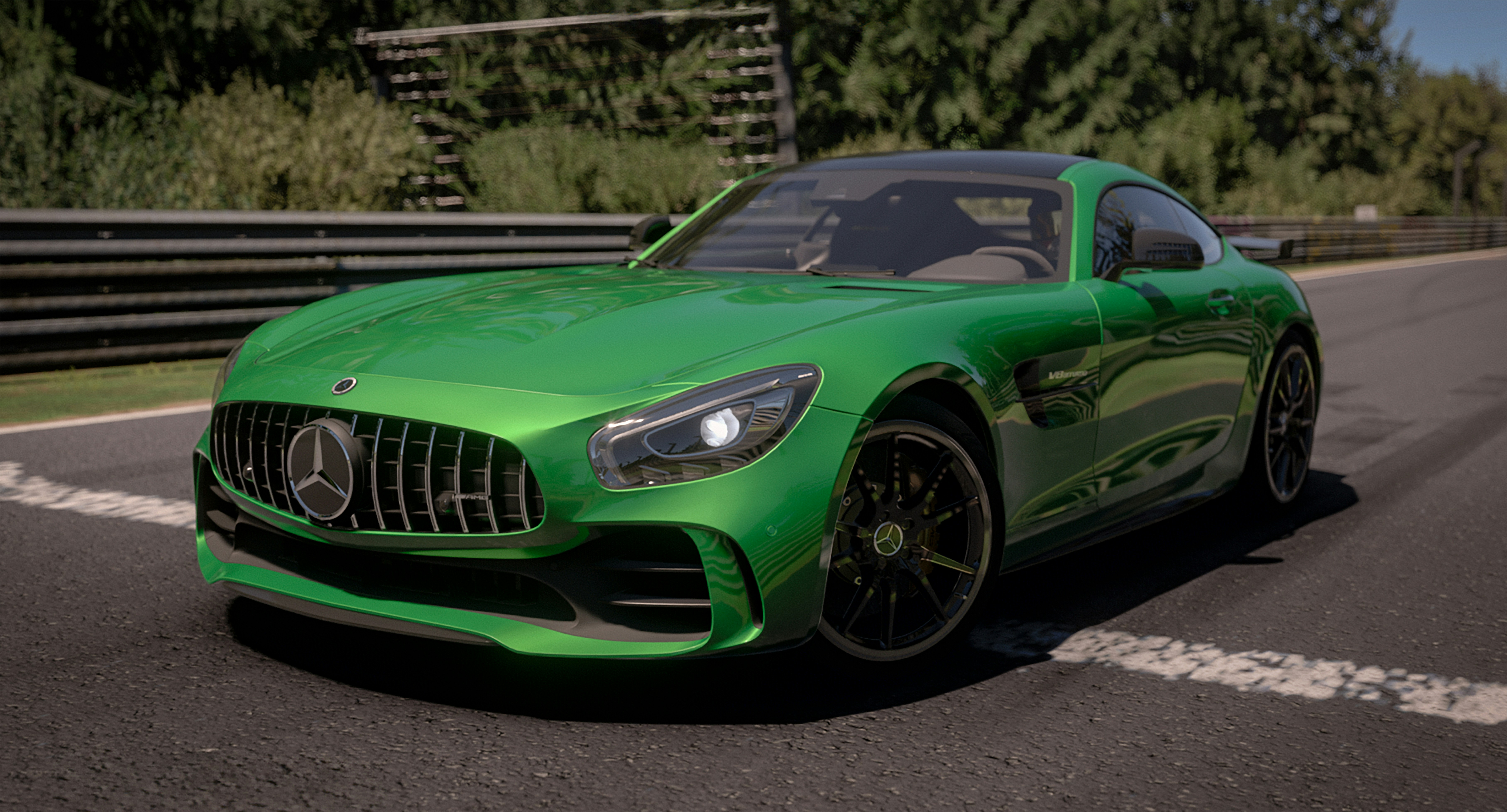 A green mercedes sports car driving on a road