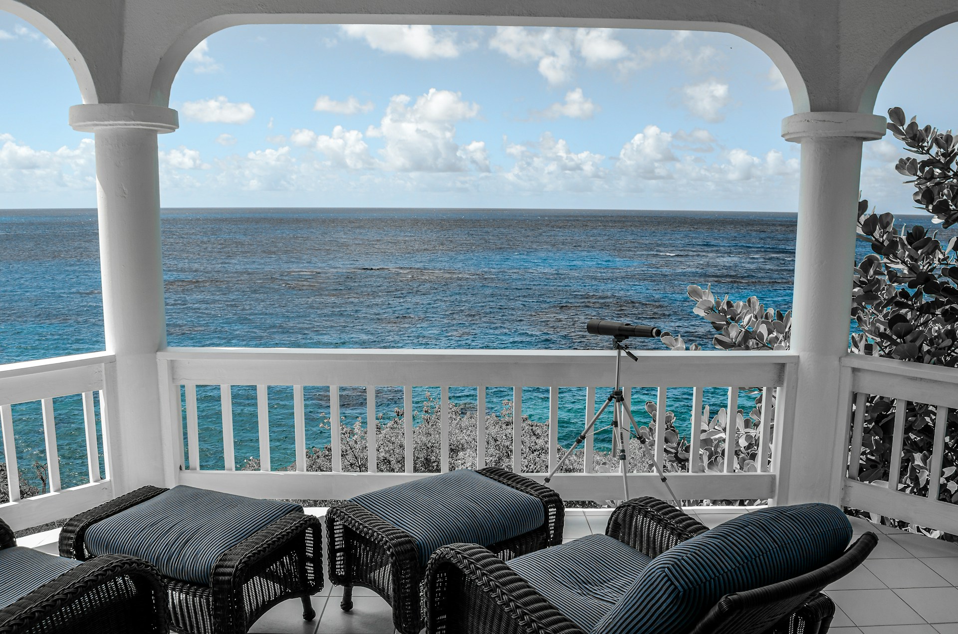 A porch with chairs and a view of the ocean