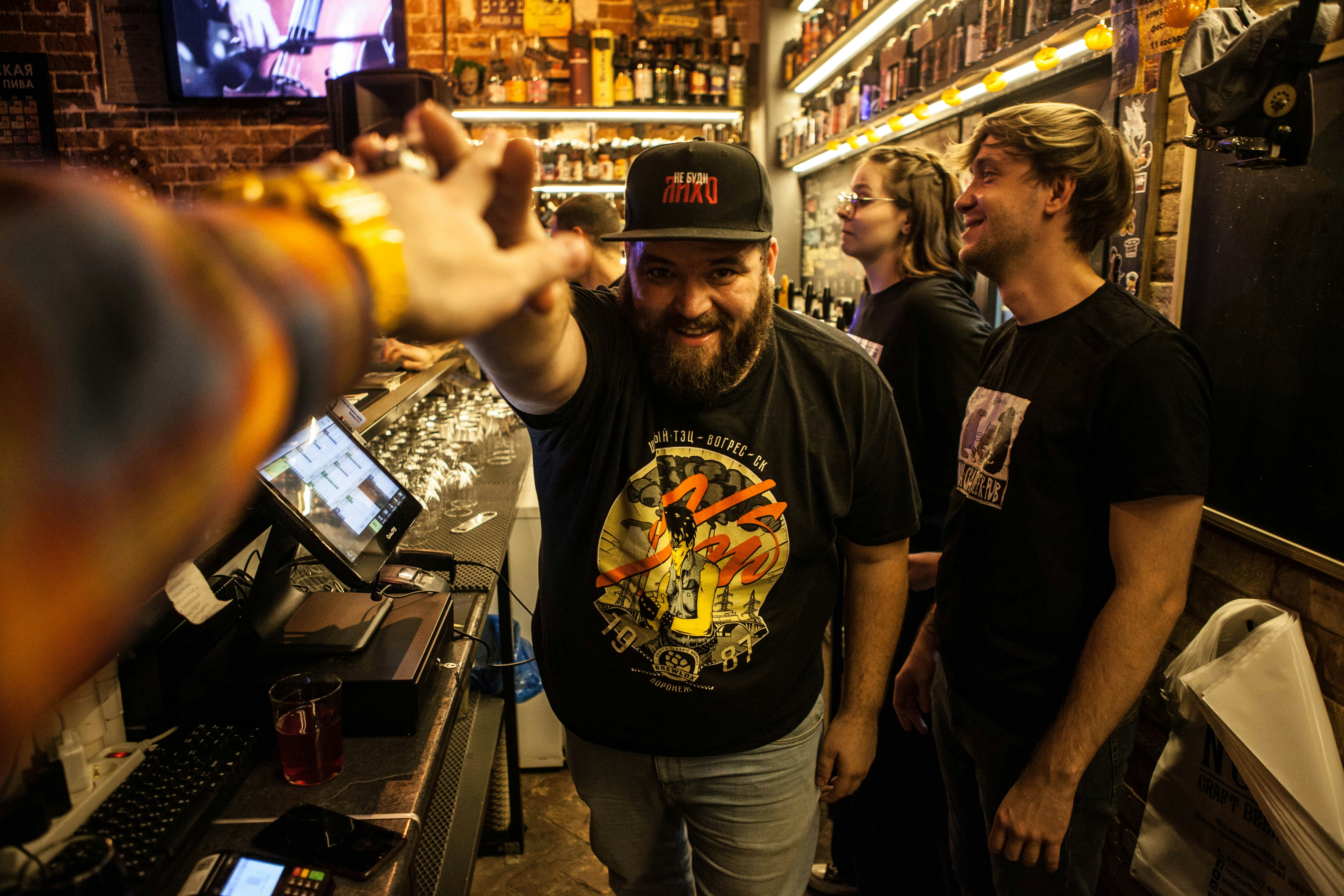 A group of people standing around a bar