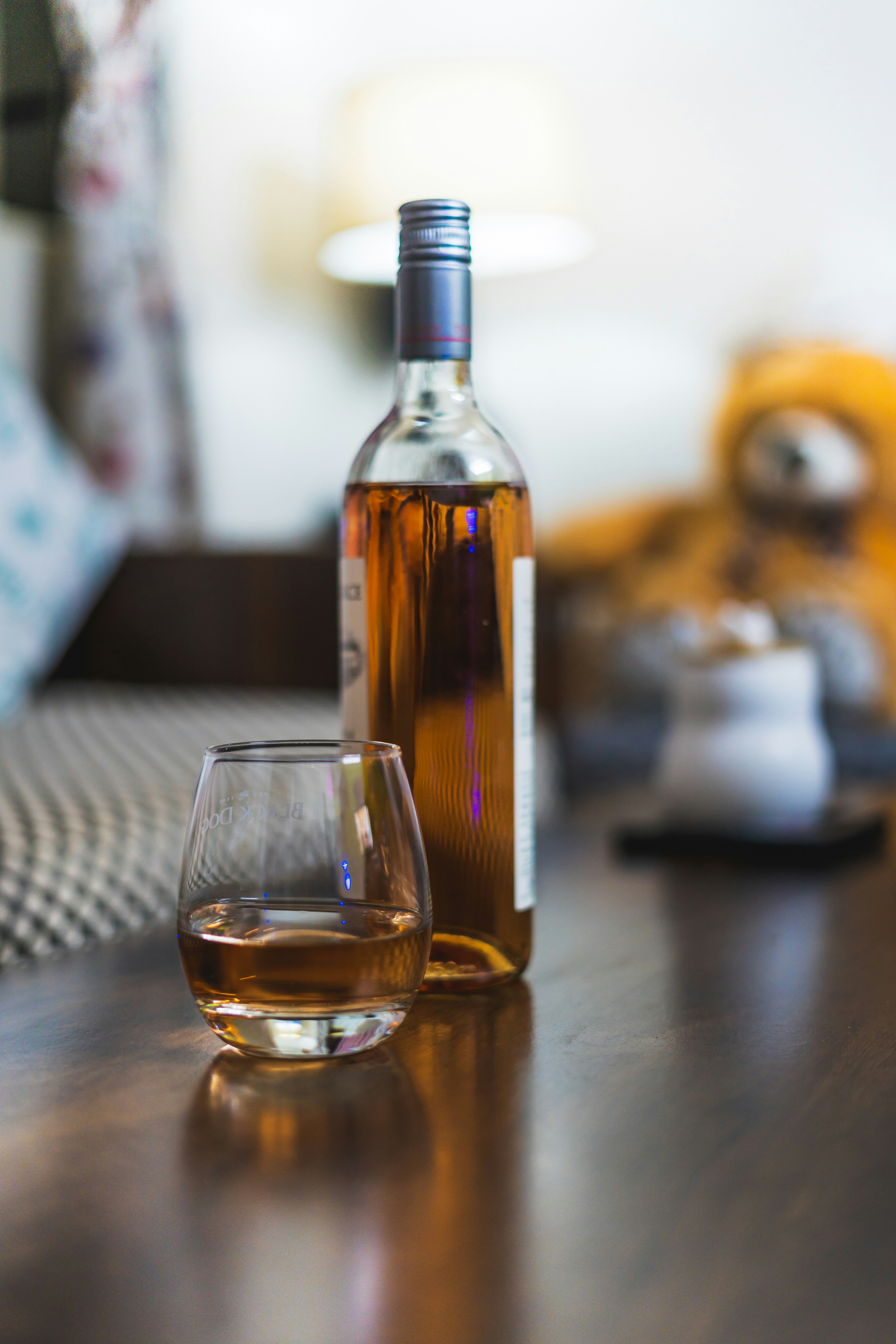 A bottle of wine and a glass on a table
