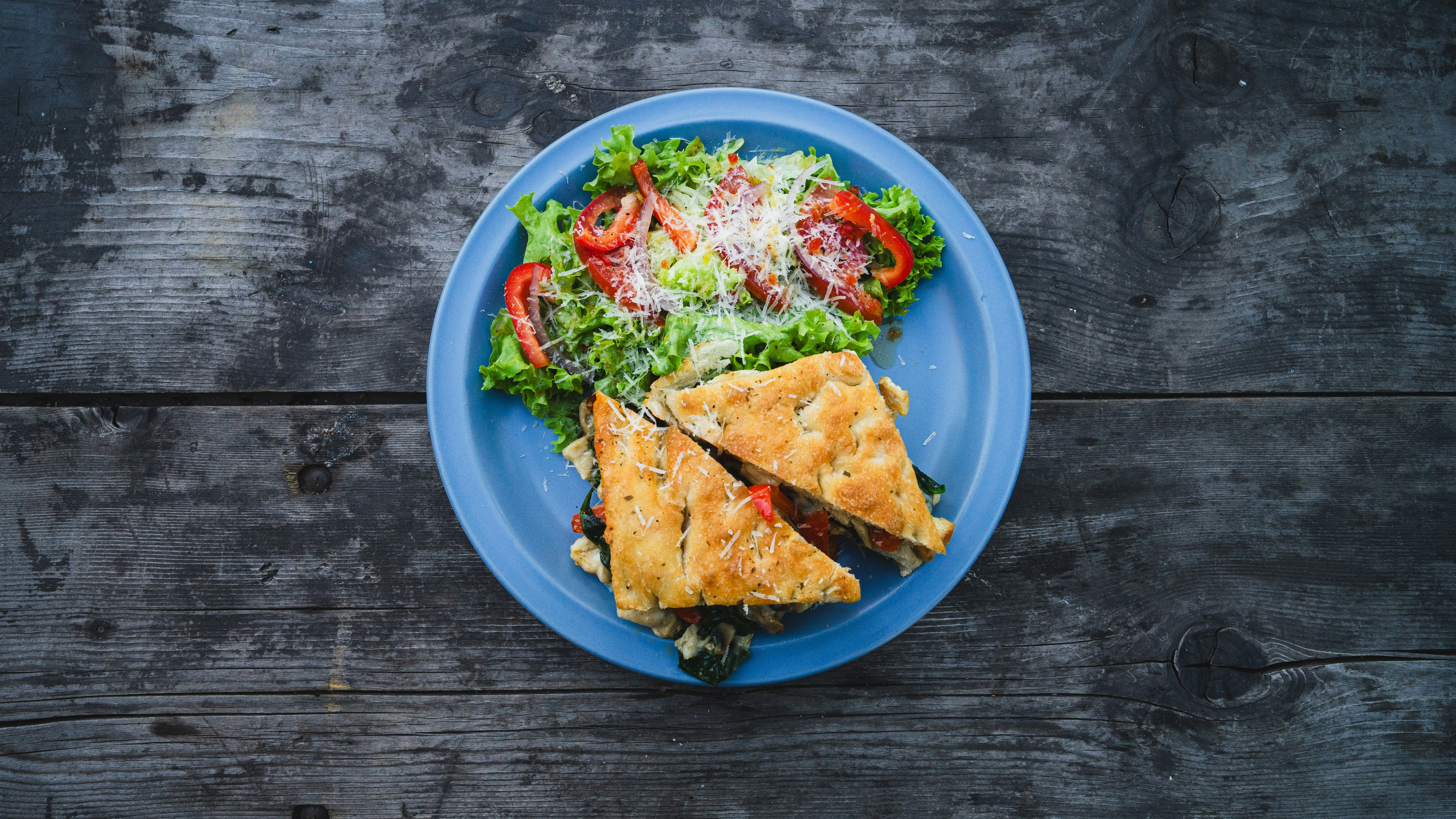 Ein blauer Teller mit Essen auf einem Holztisch