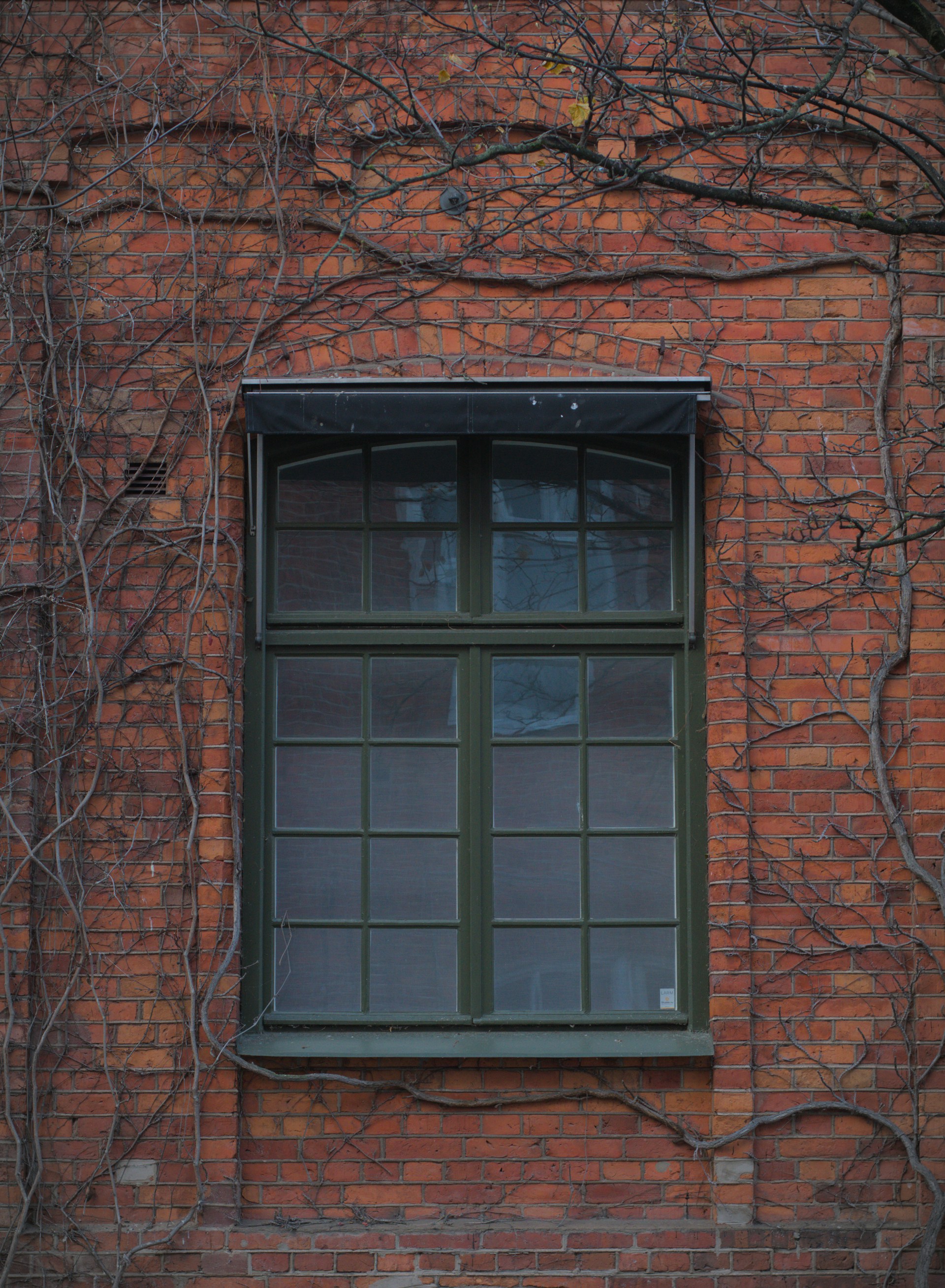 A red brick building with a green window