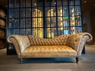 A couch sitting in front of a glass wall