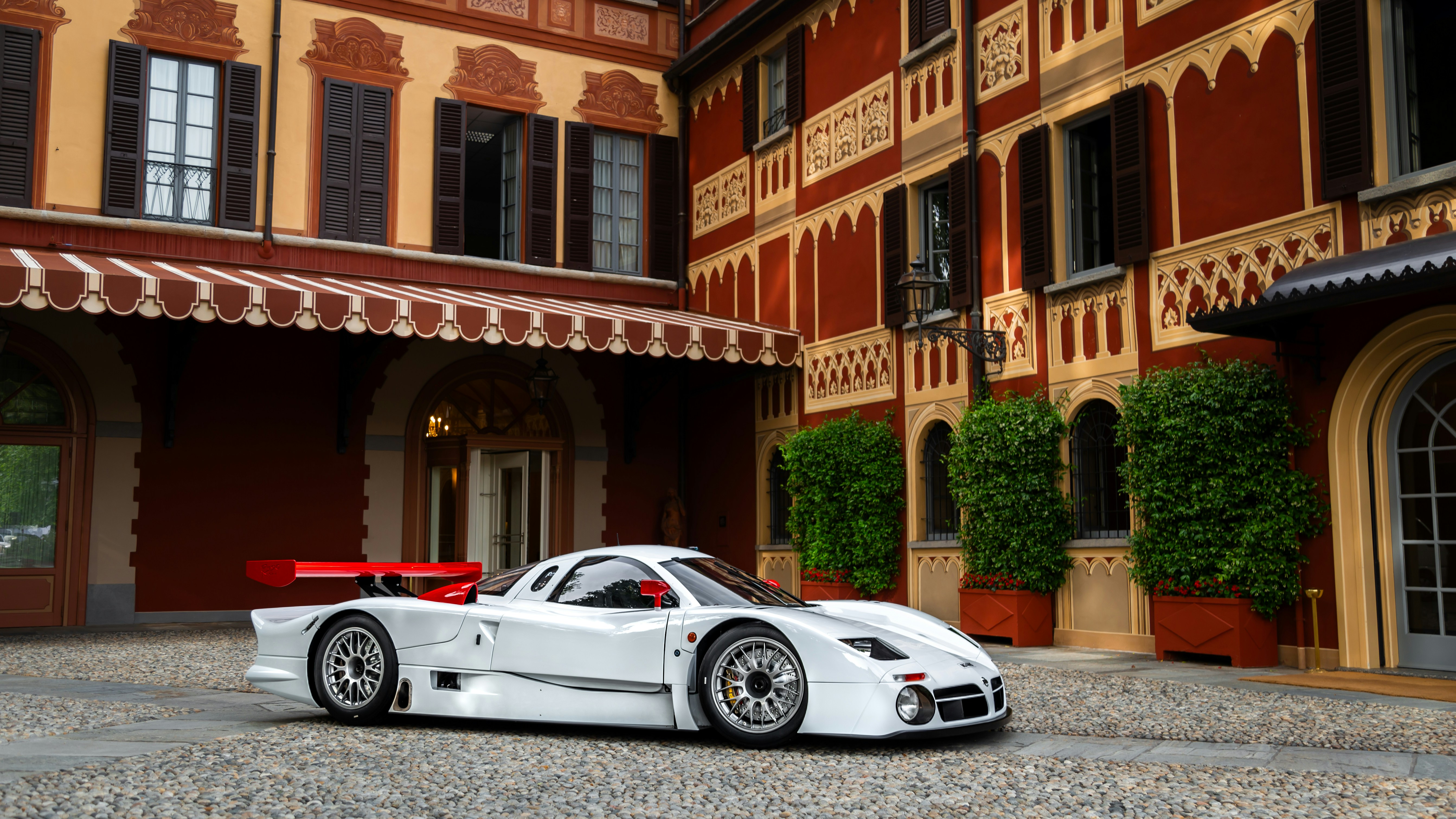 A white sports car parked in front of a building