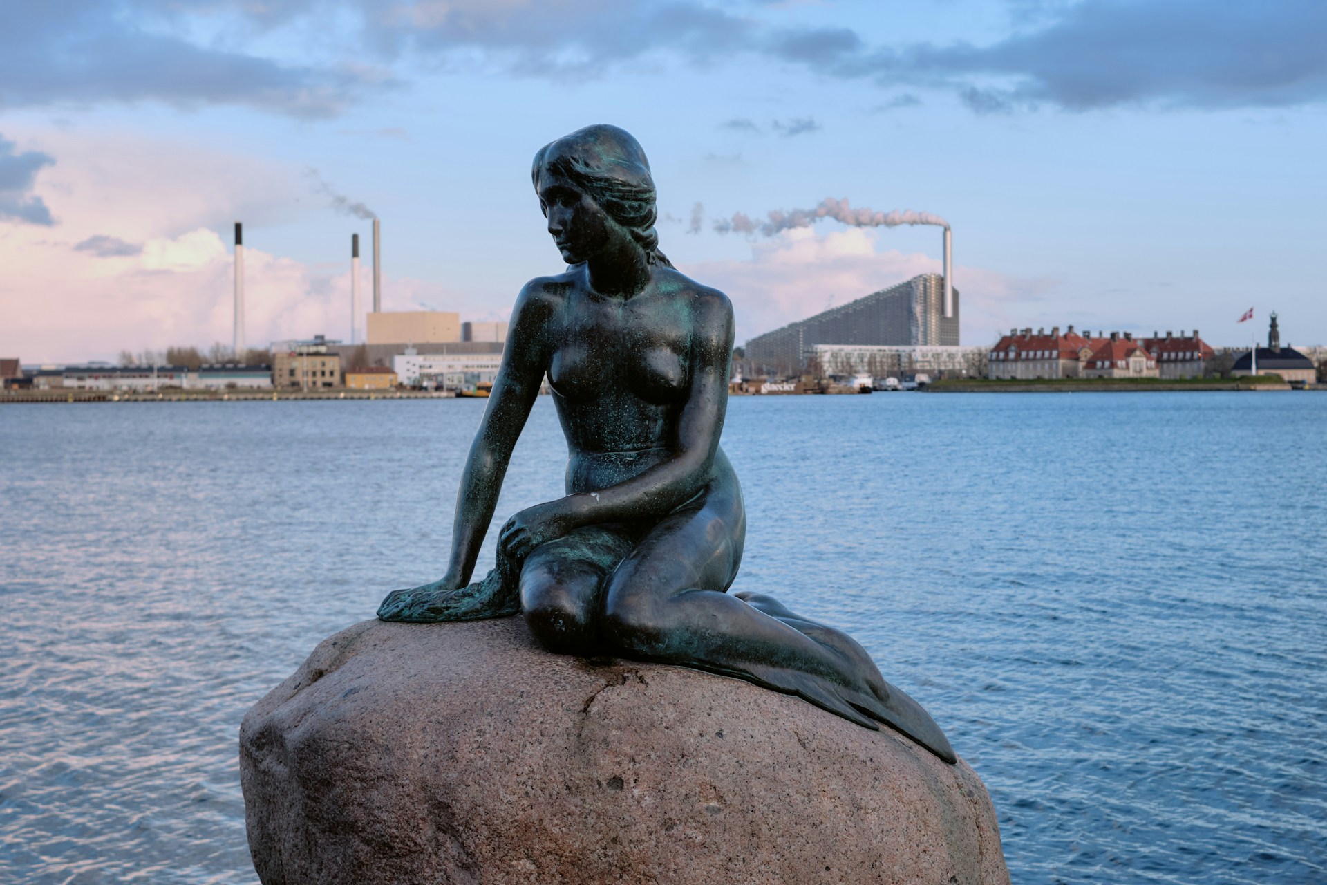 A statue of a woman sitting on top of a rock
