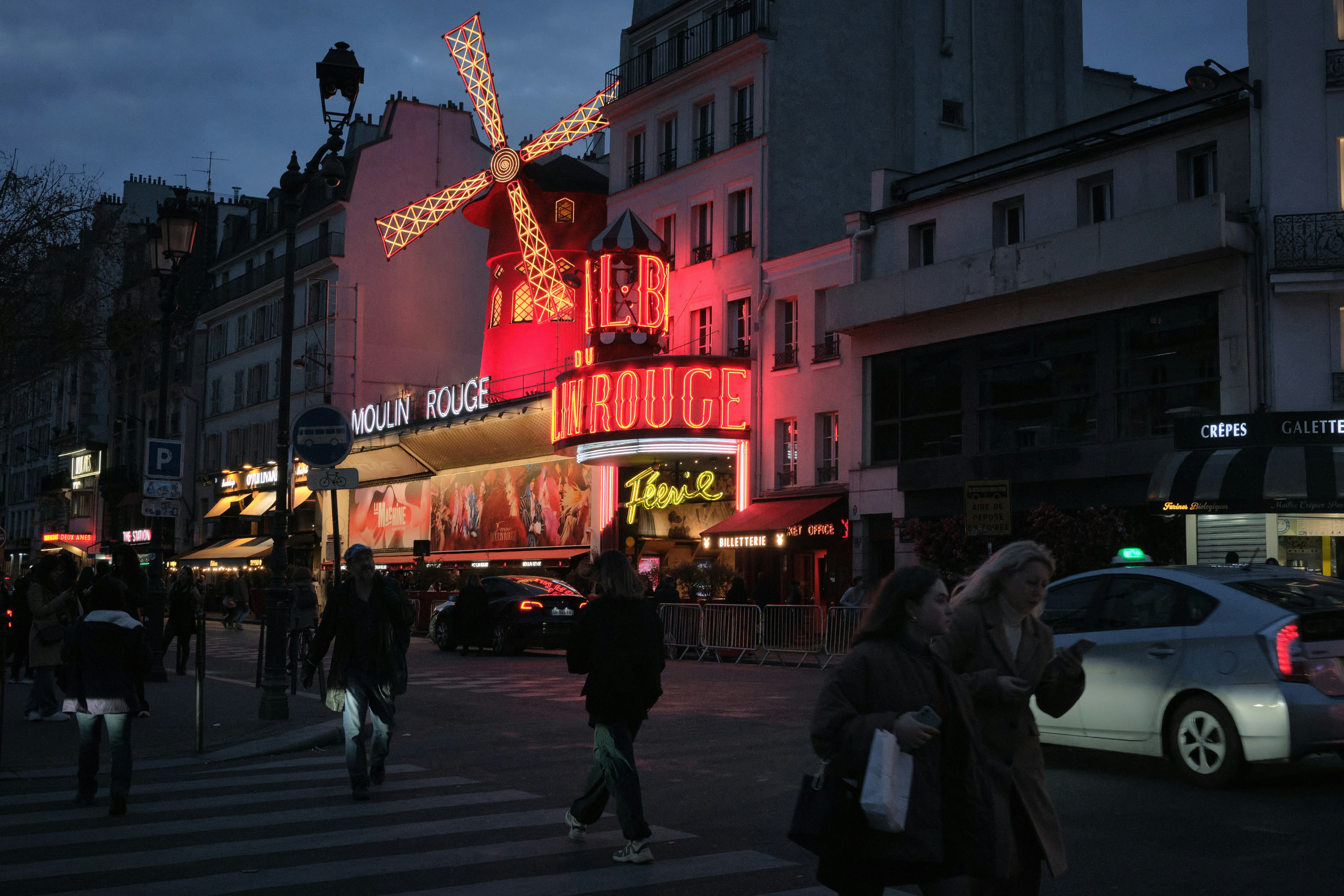 A group of people walking across a street