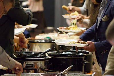 A group of people standing around a buffet line