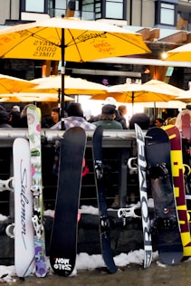 A group of snowboarders sitting under yellow umbrellas