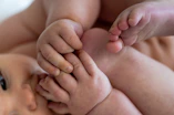 A close up of a baby laying on its back
