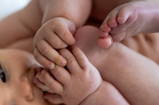 A close up of a baby laying on its back