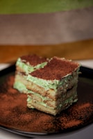 A piece of cake sitting on top of a black plate