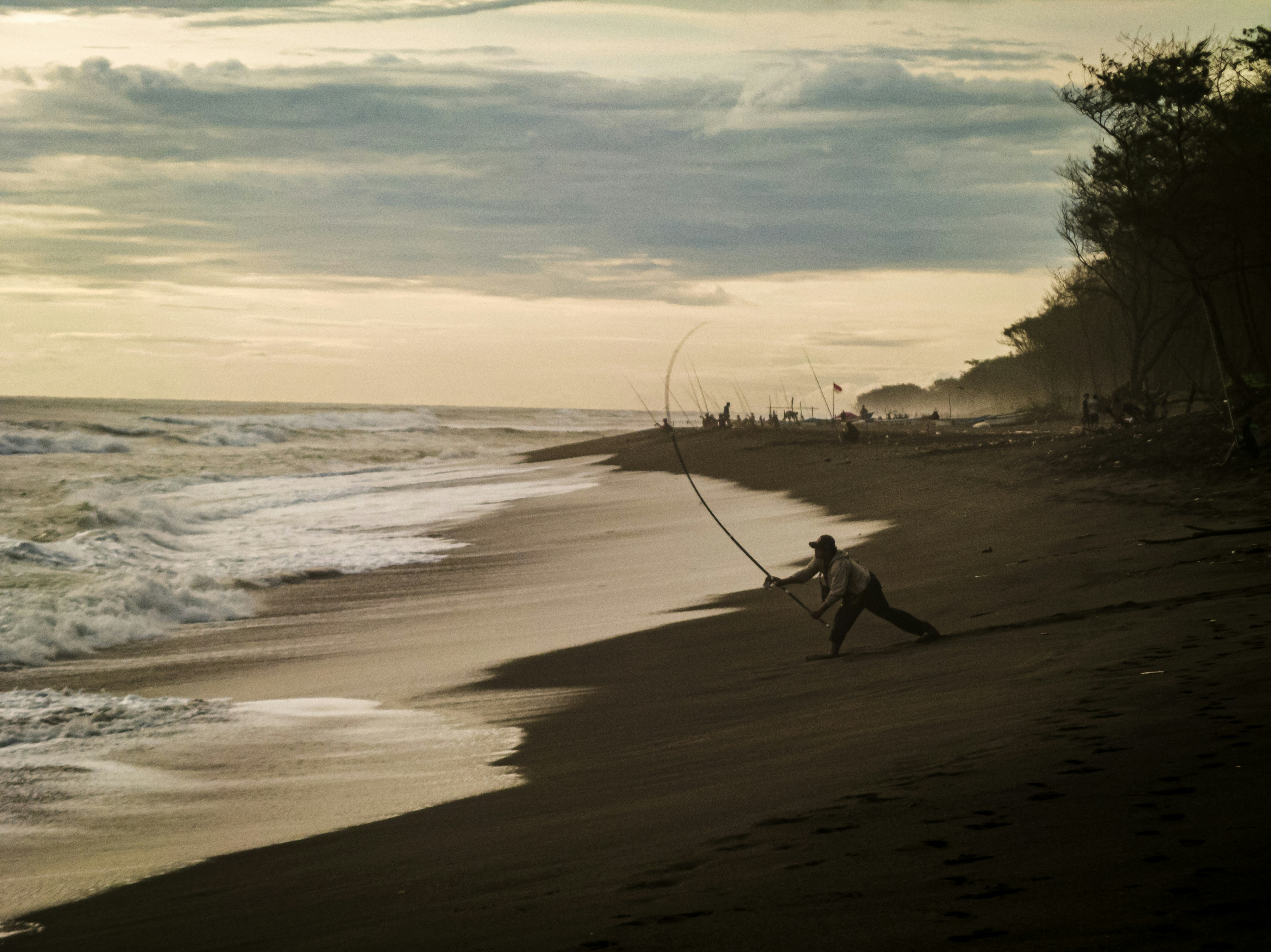 A man walking along a beach next to the ocean