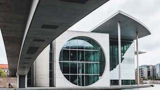 A large building with a circular window next to a body of water