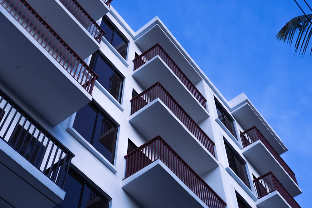 Modern apartment block with rows of balconies against a blue sky