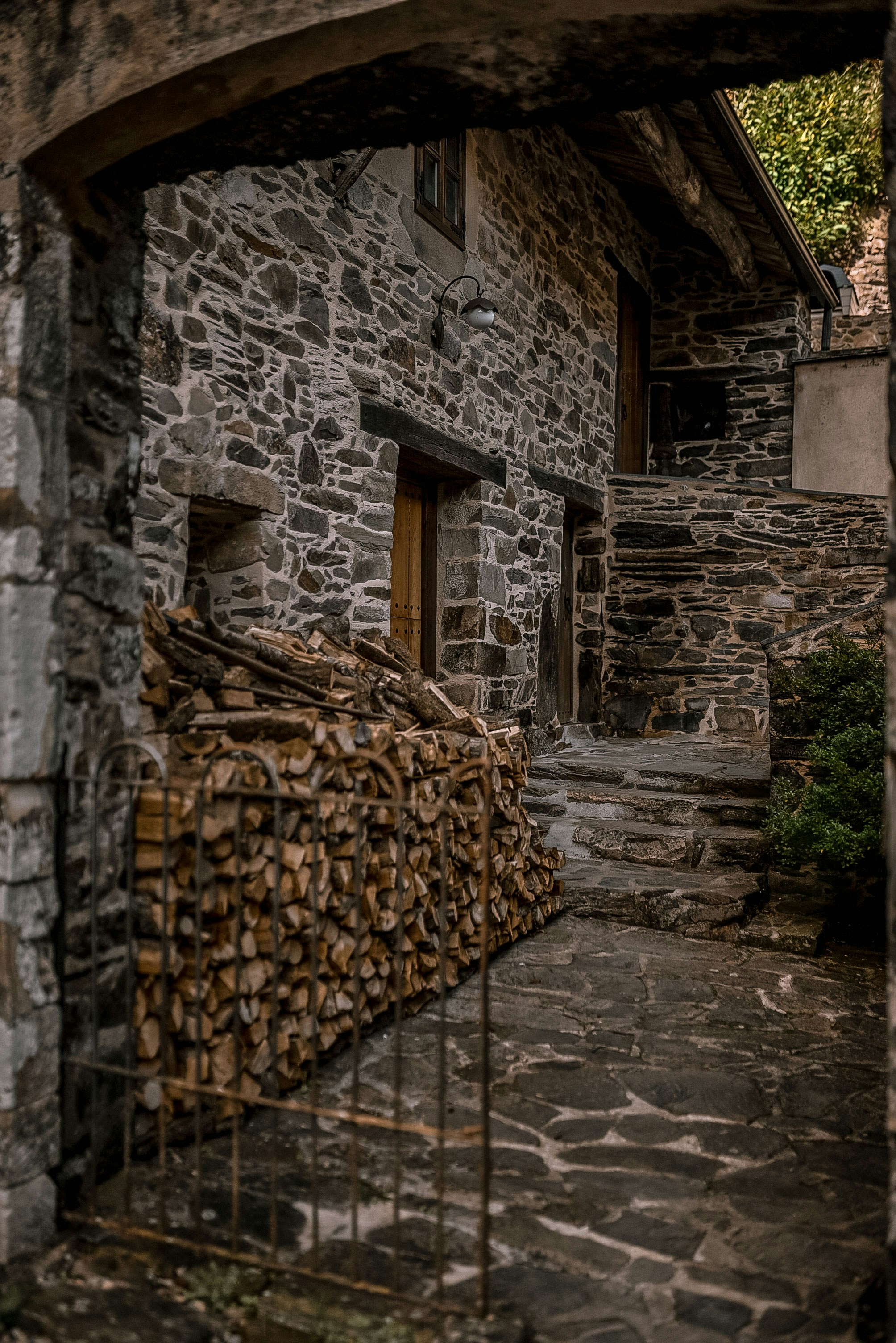 A stone building with a bunch of logs in front of it