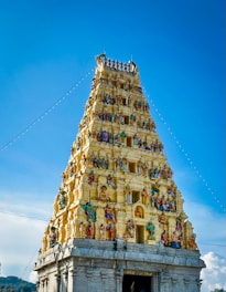 A very tall tower with statues on it