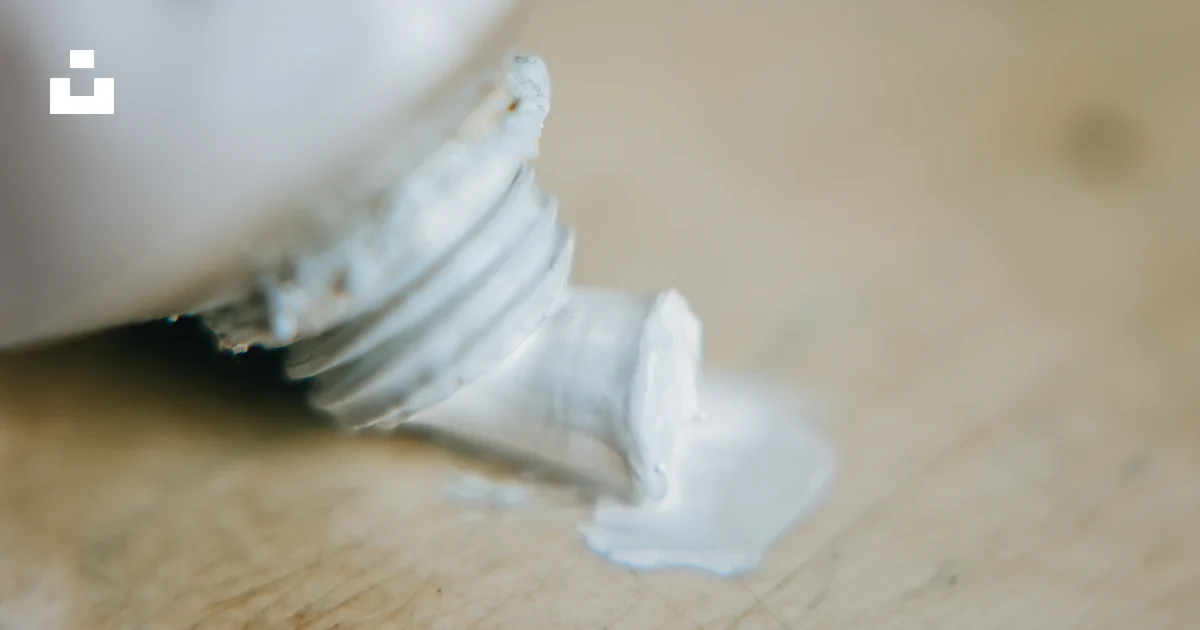 A close up of a tube of toothpaste on a table photo – Free Painting ...