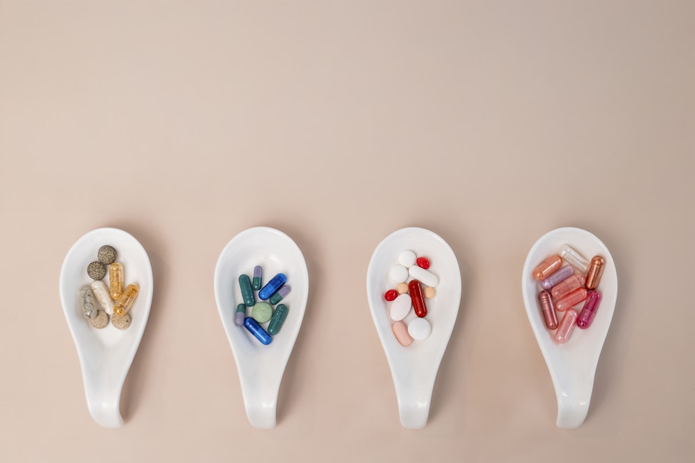 A row of spoons filled with different types of pills