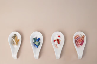 A row of spoons filled with different types of pills