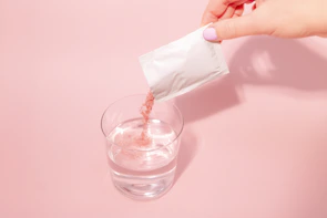 A person pouring a drink into a glass