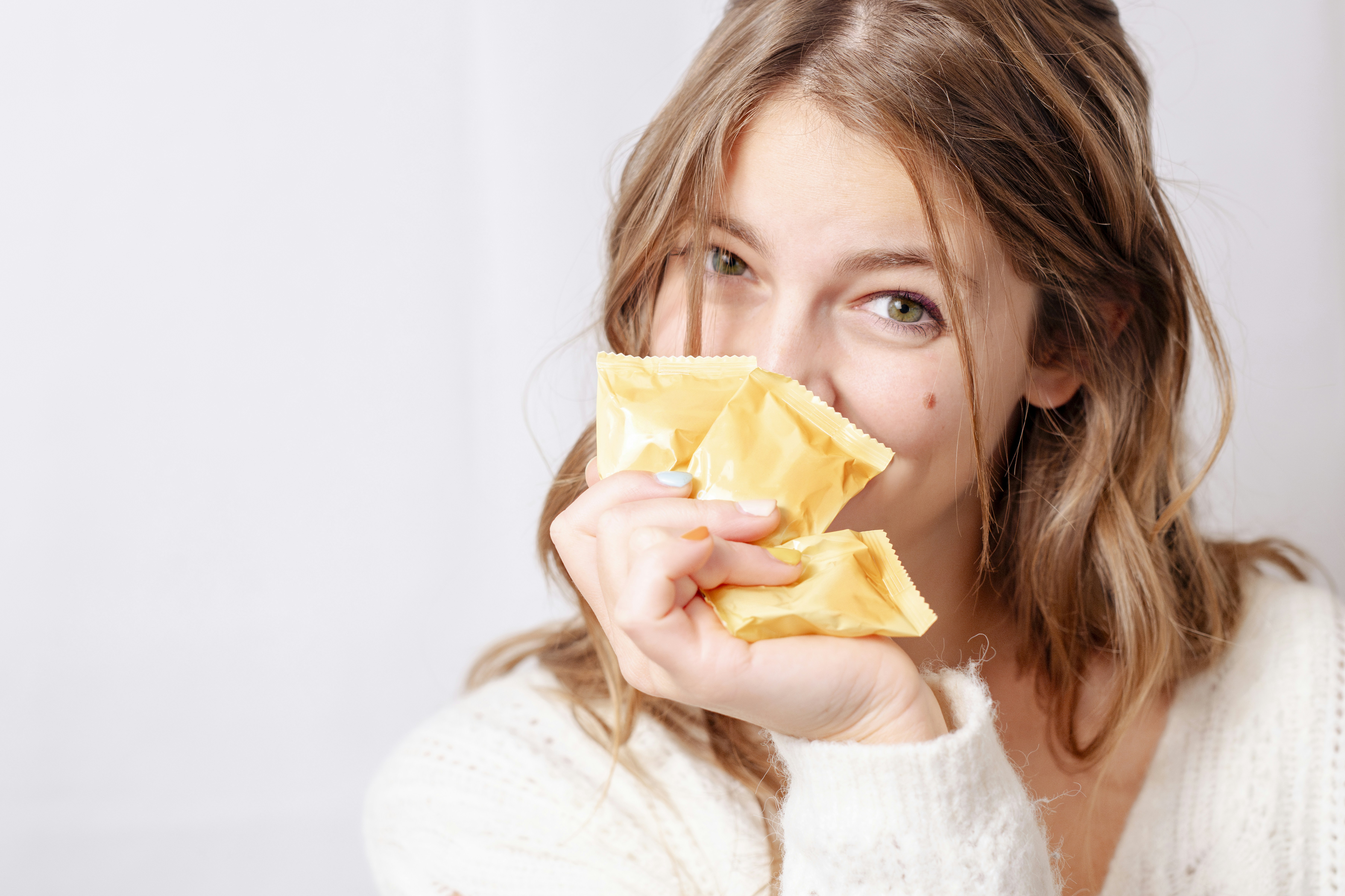 A woman holding a piece of food up to her face