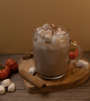 A cup of hot chocolate with marshmallows on a cutting board