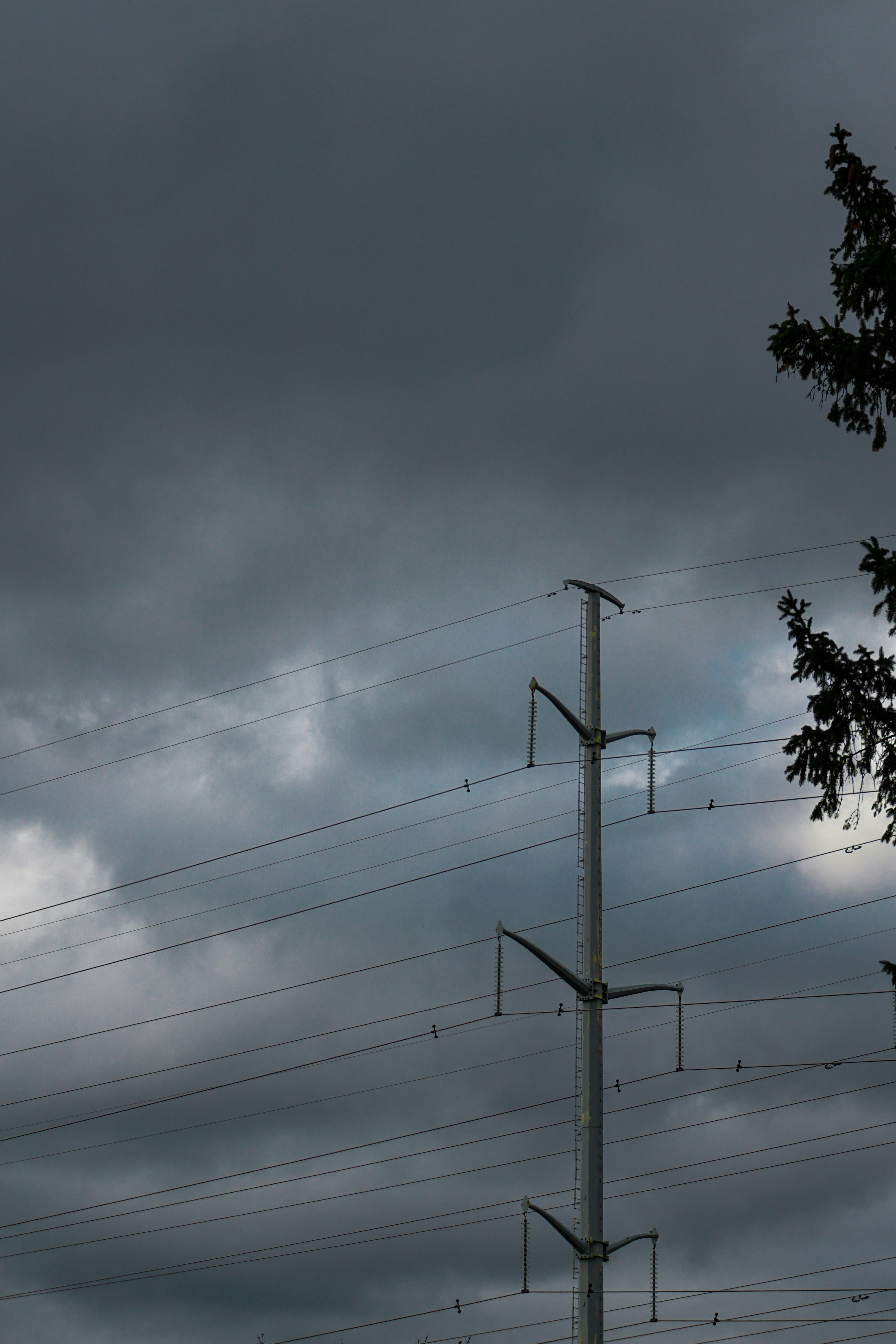 A telephone pole in front of a cloudy sky