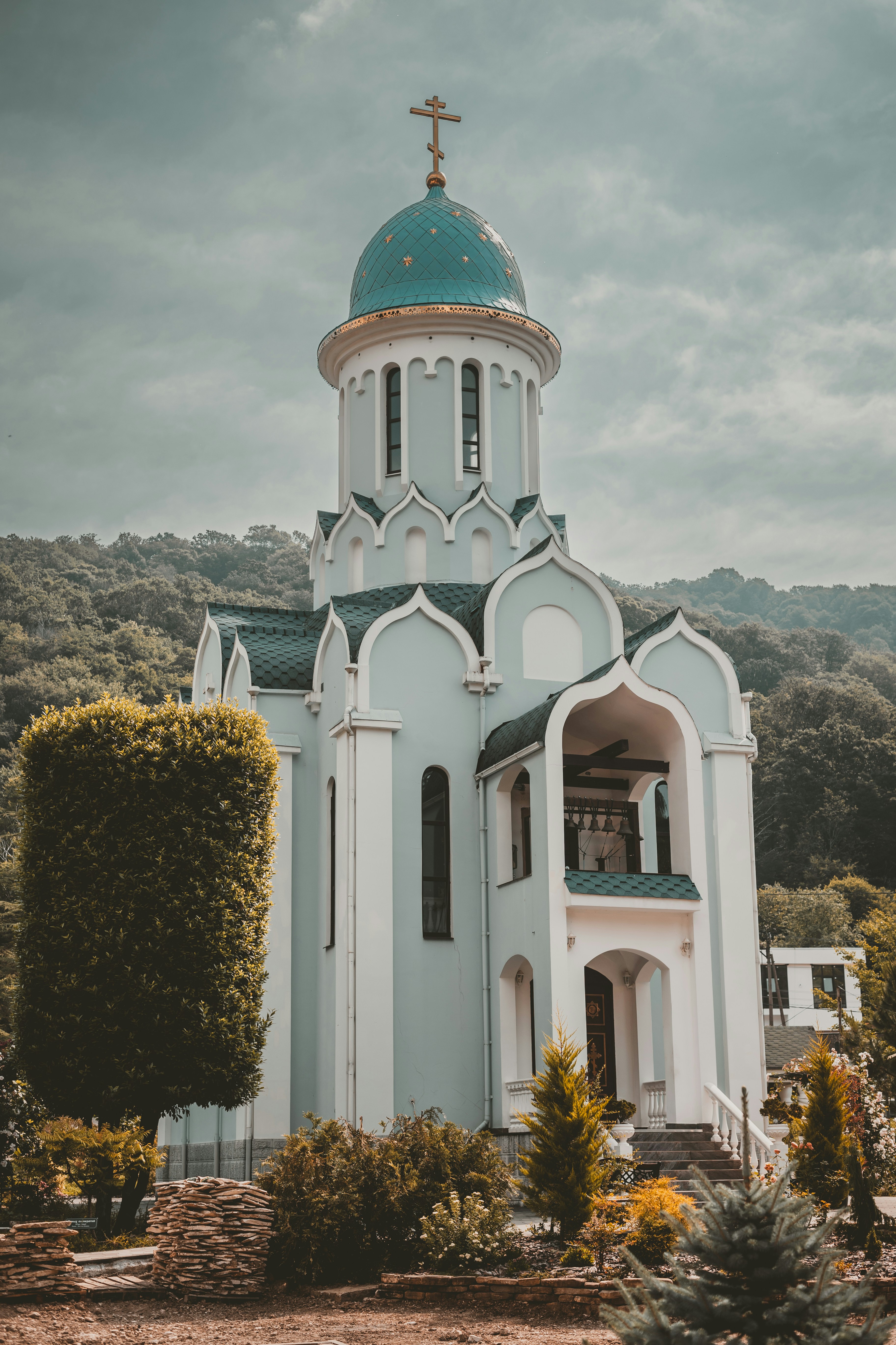 Uma igreja branca e azul com uma cruz no topo