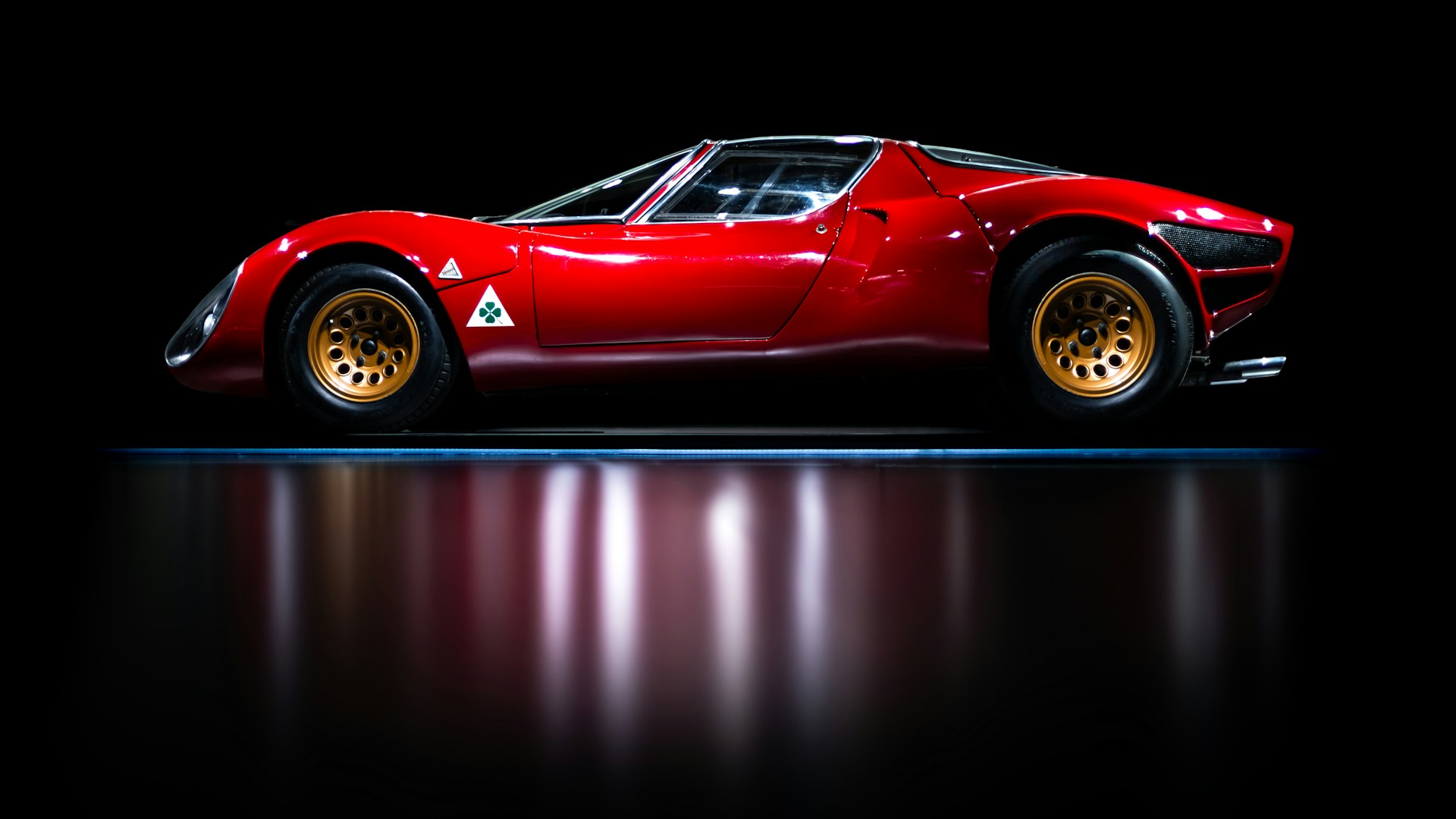 A red sports car sitting on top of a black floor