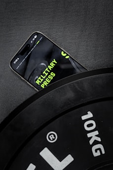 A cell phone sitting on top of a black clock