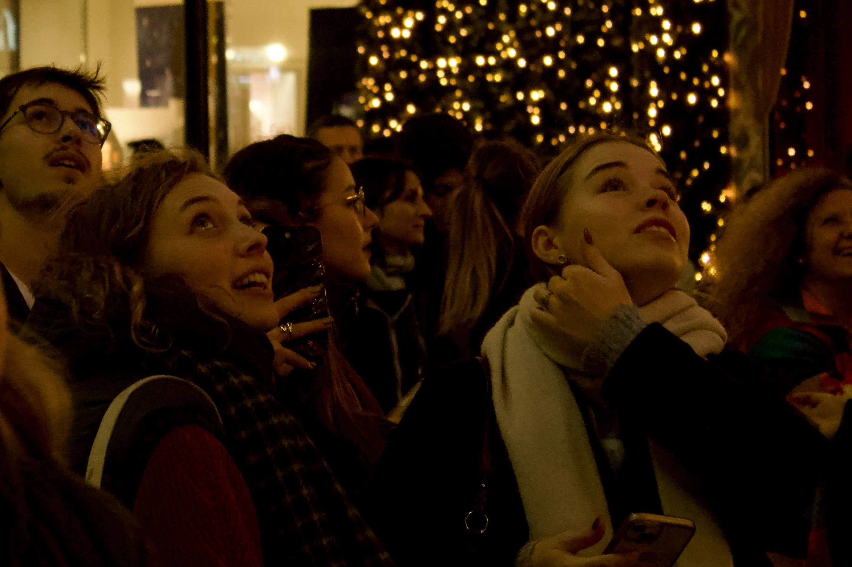 Eine Gruppe von Menschen steht vor einem Weihnachtsbaum