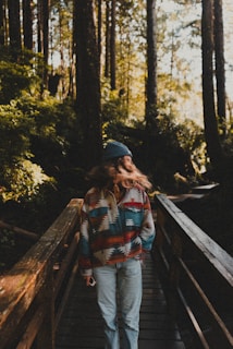 A woman walking across a wooden bridge in the woods
