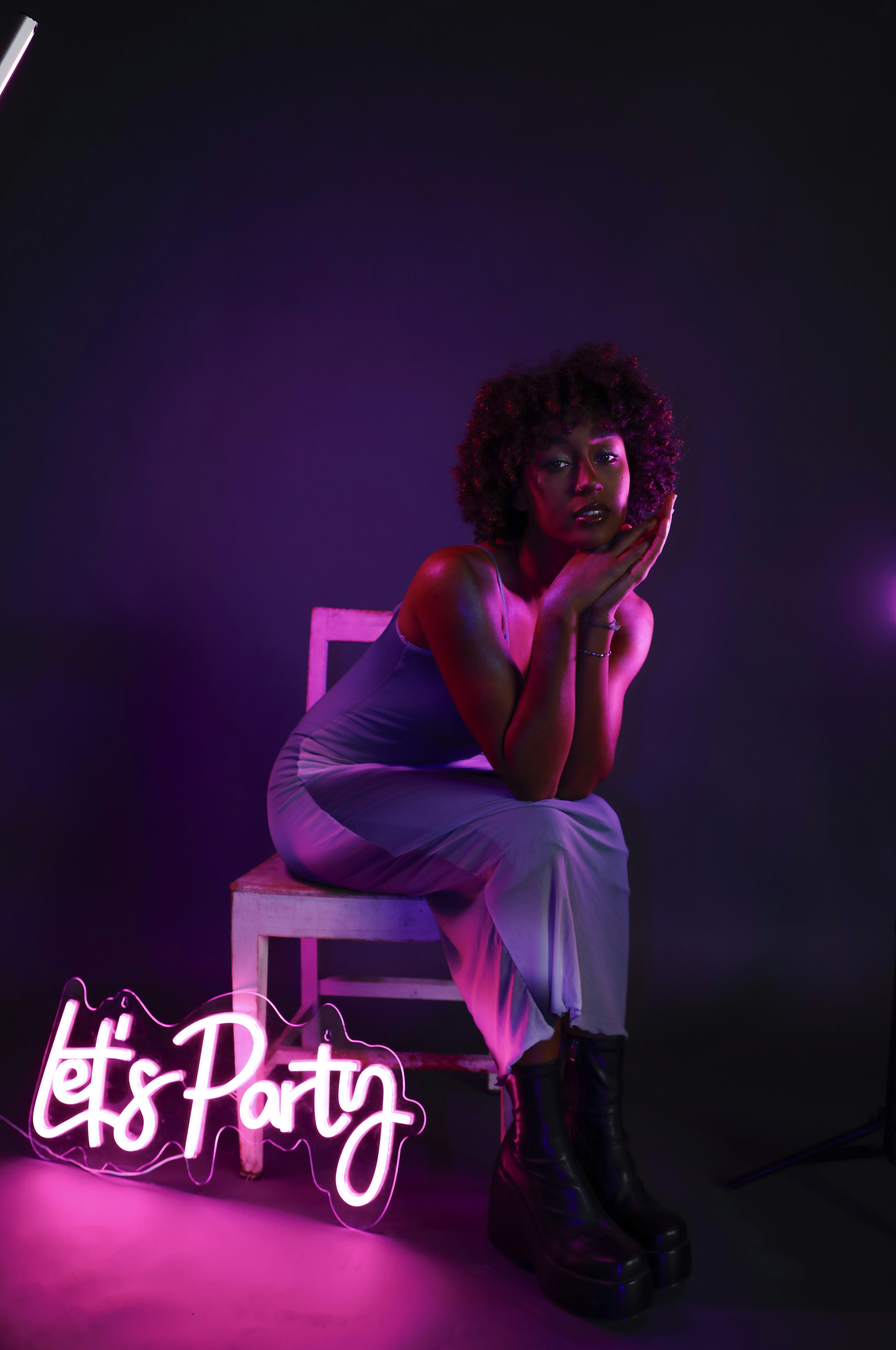 Une femme assise sur une chaise dans une pièce sombre