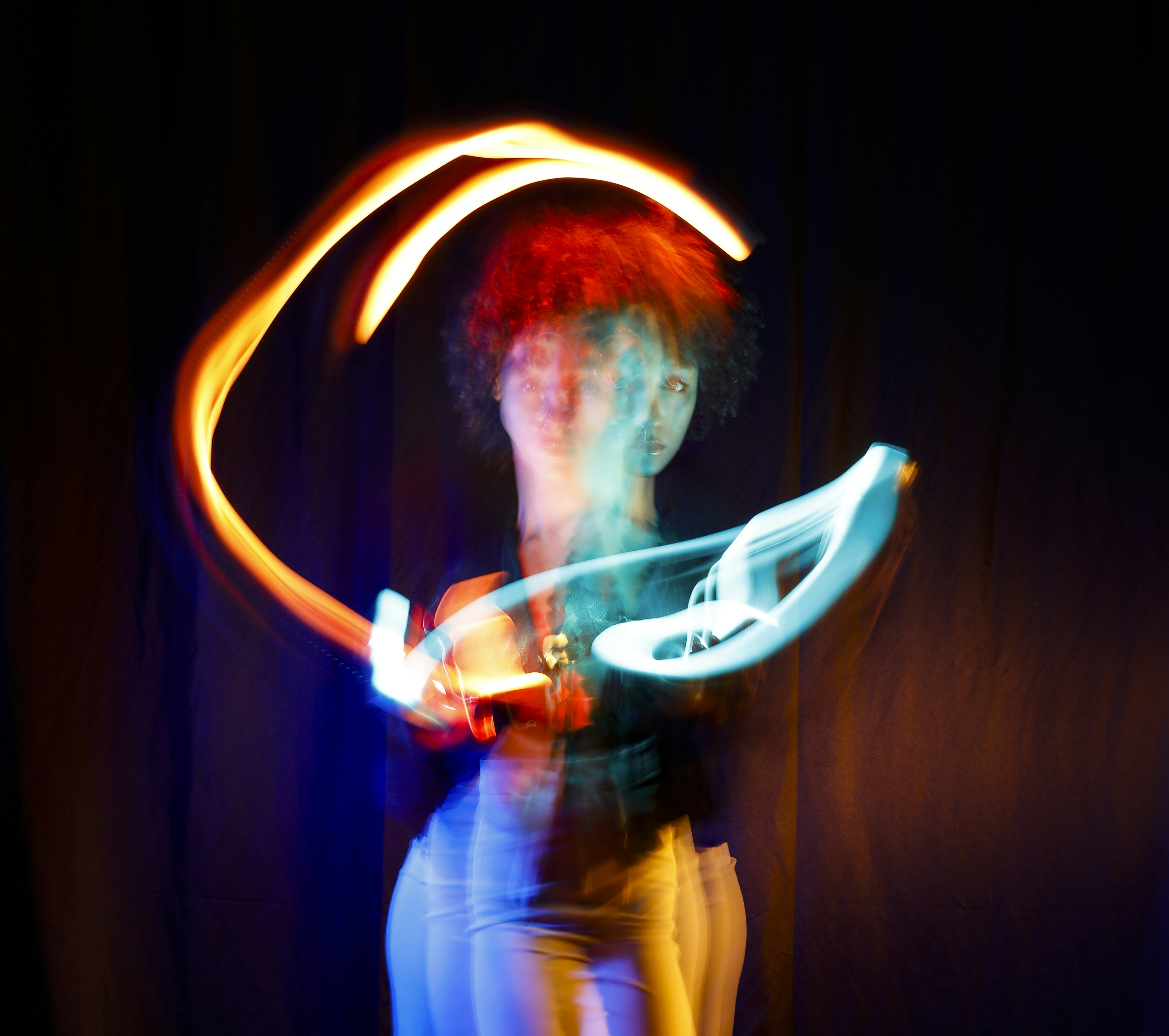 Une femme tenant un frisbee tout en se tenant devant un fond sombre