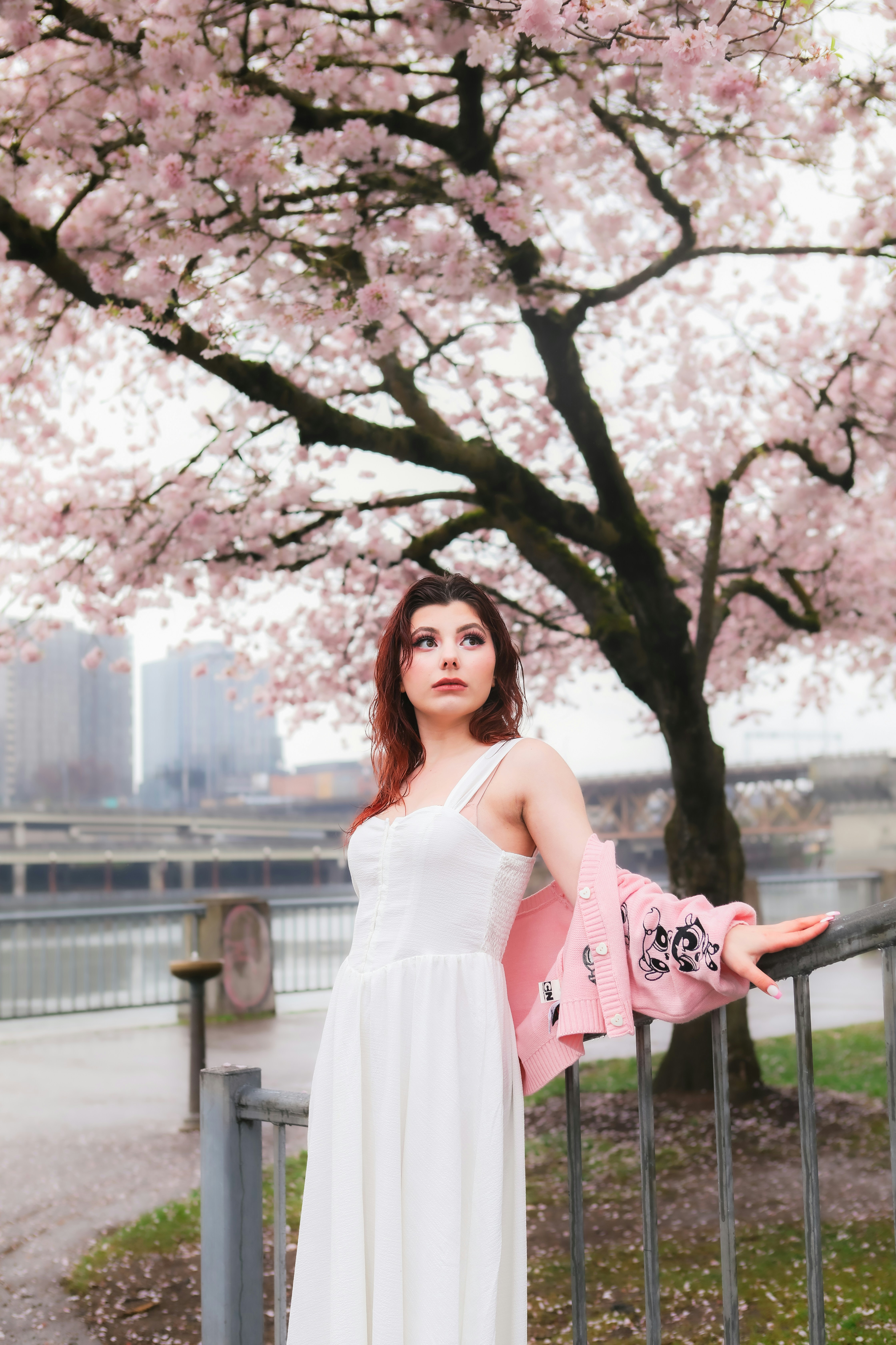 Une femme en robe blanche debout sous un arbre
