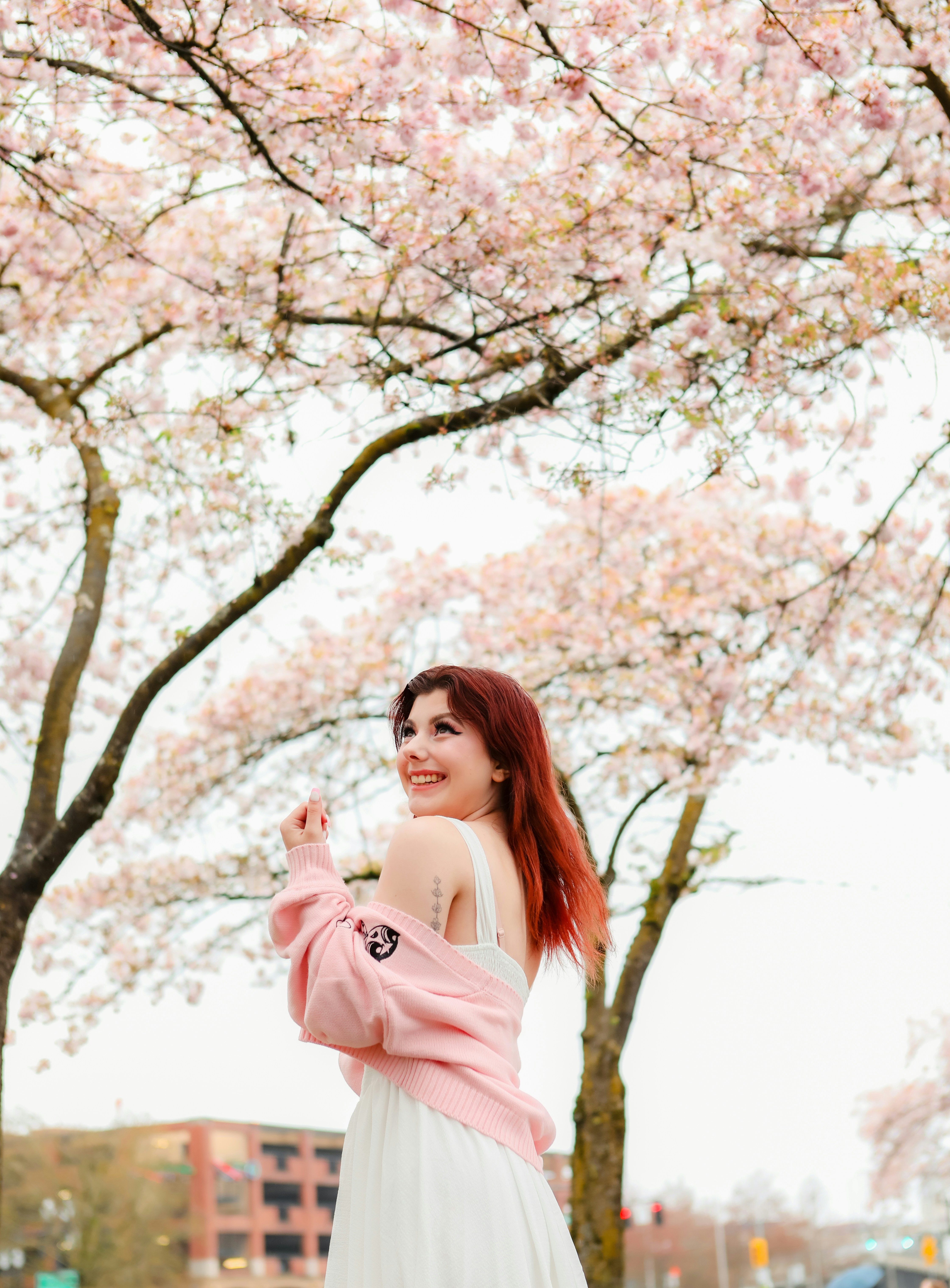 Une femme en robe blanche debout devant un arbre