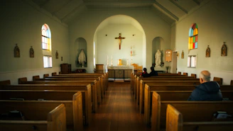 A man sitting in a church with stained glass windows