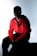 A man in a red jacket is sitting down