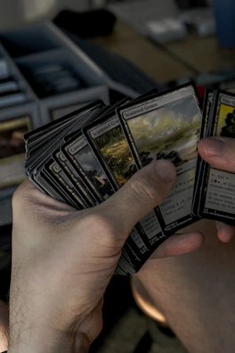 A person holding a bunch of magic the gathering cards in their hands