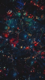 A very colorful christmas tree with ornaments on it