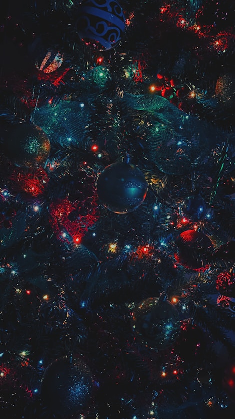 A very colorful christmas tree with ornaments on it