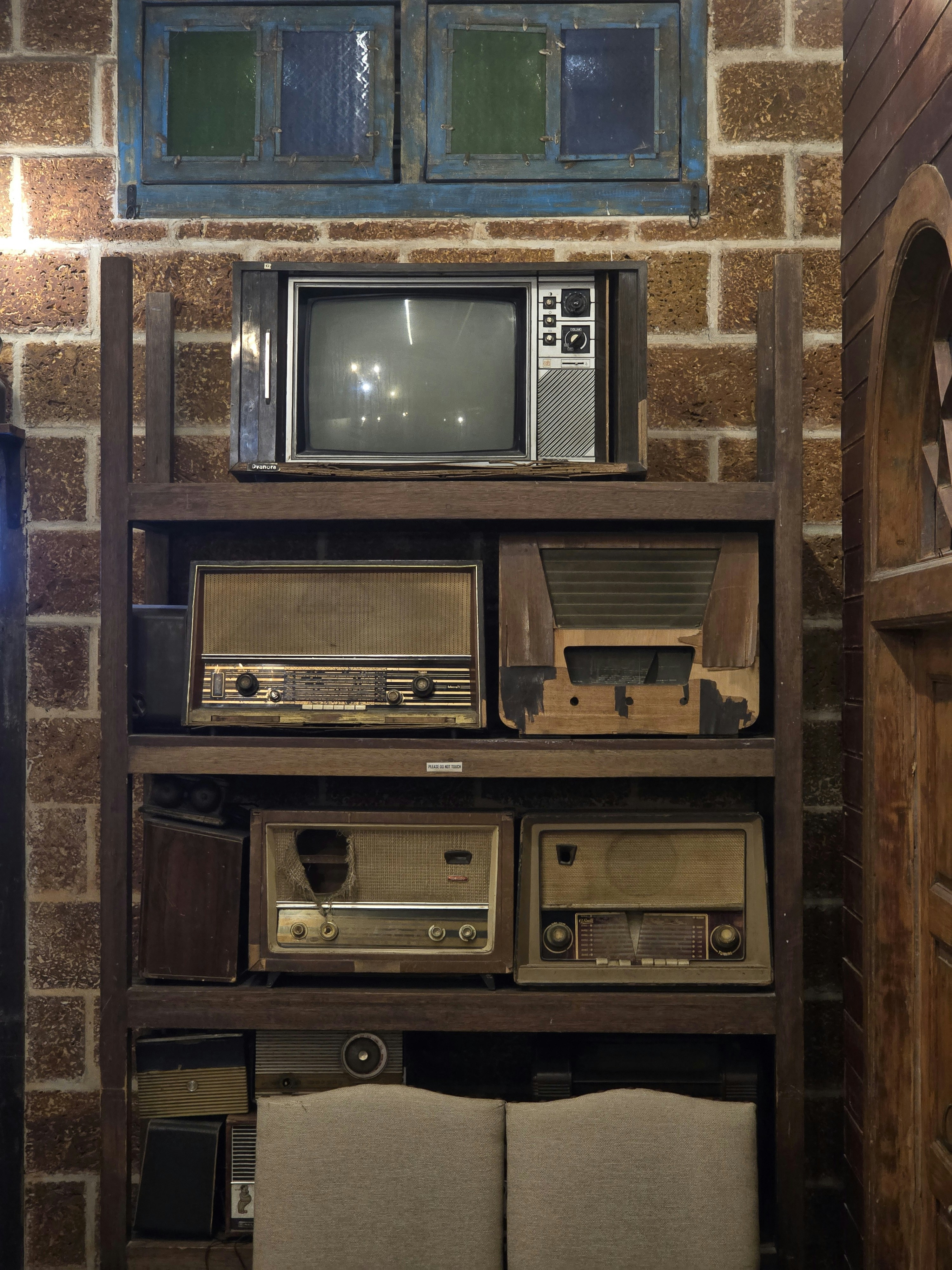 A room with a bunch of old tvs on a shelf