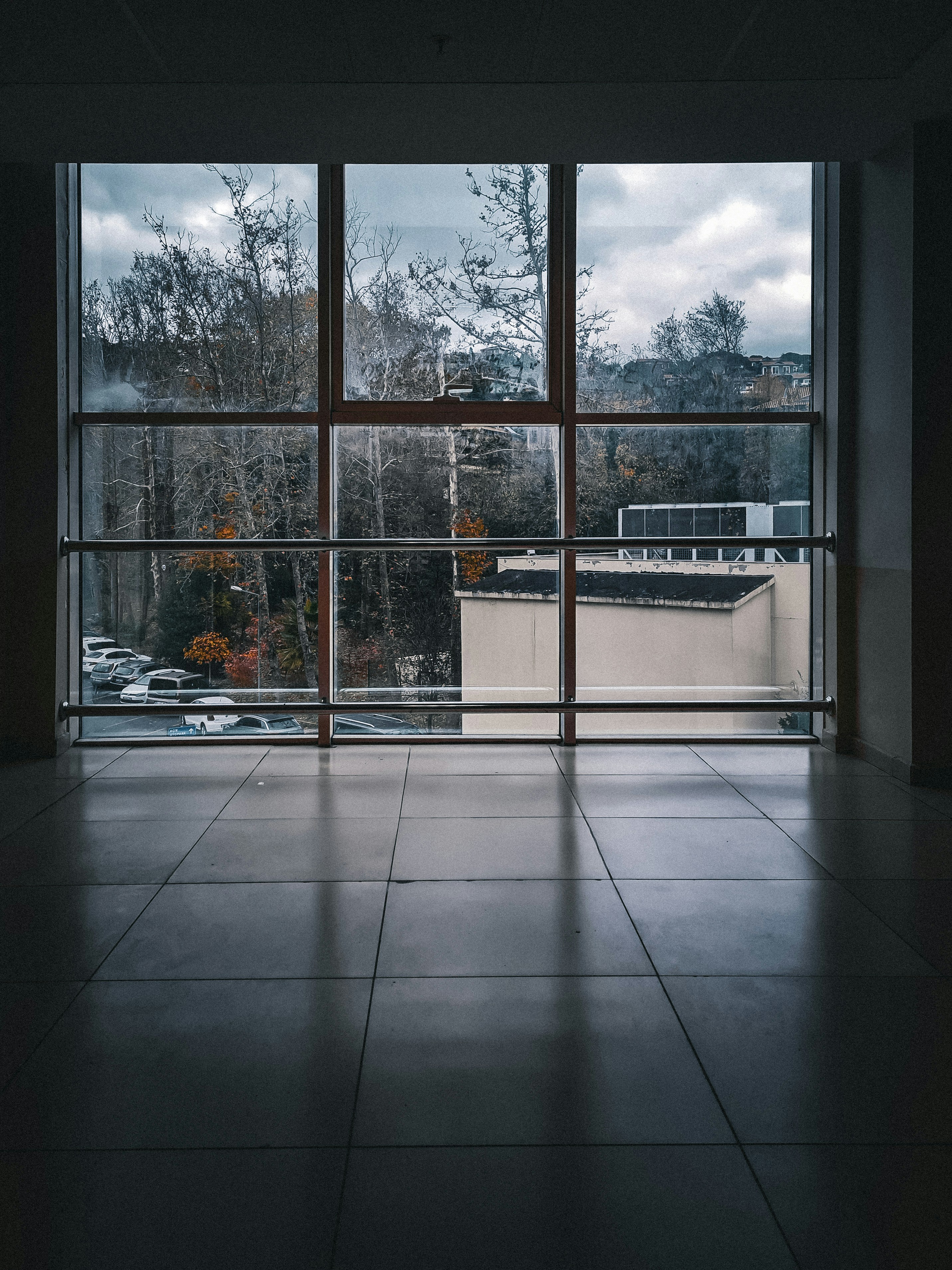 An empty room with a large window overlooking a parking lot