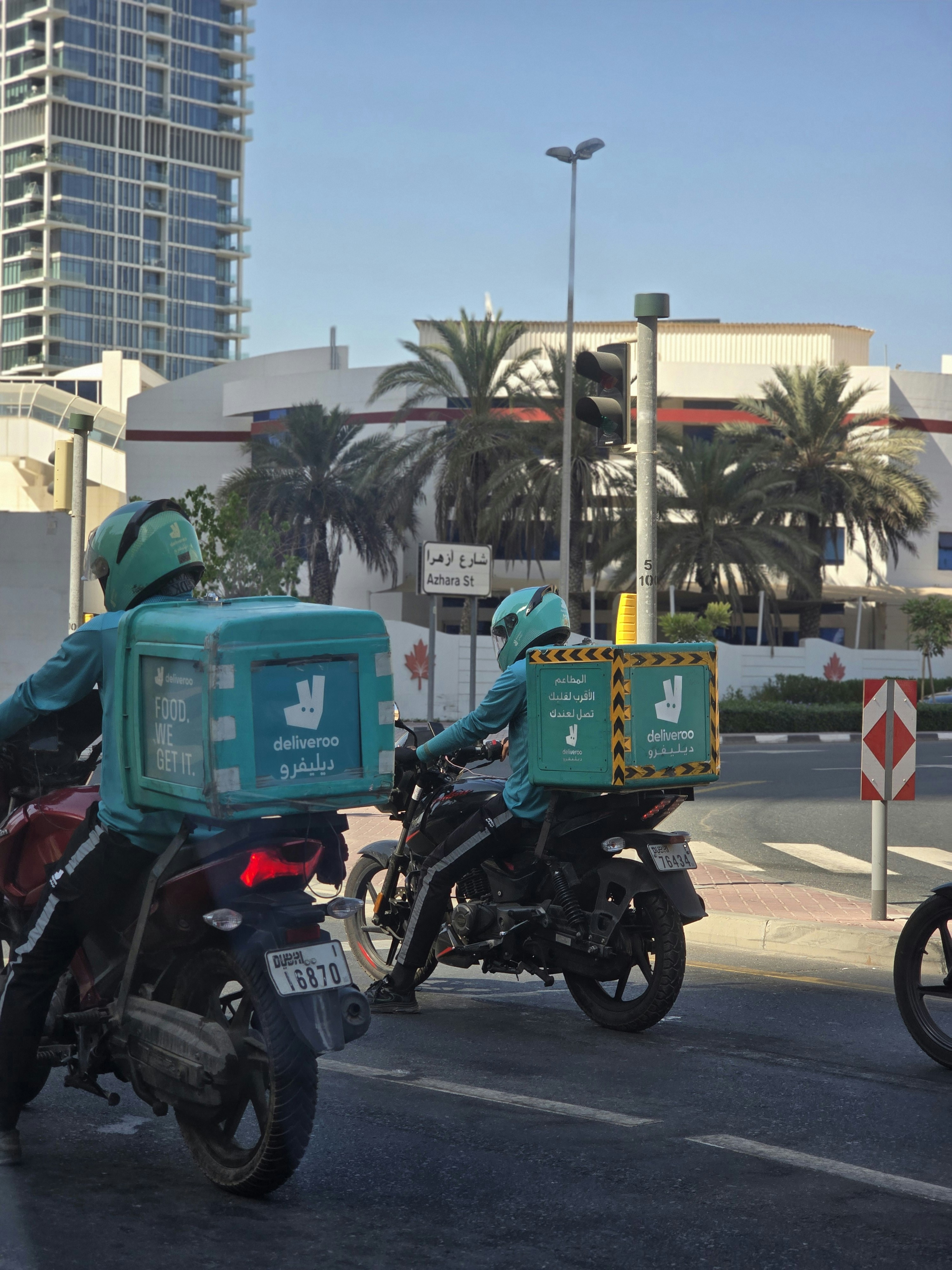 A group of people riding motorcycles down a street