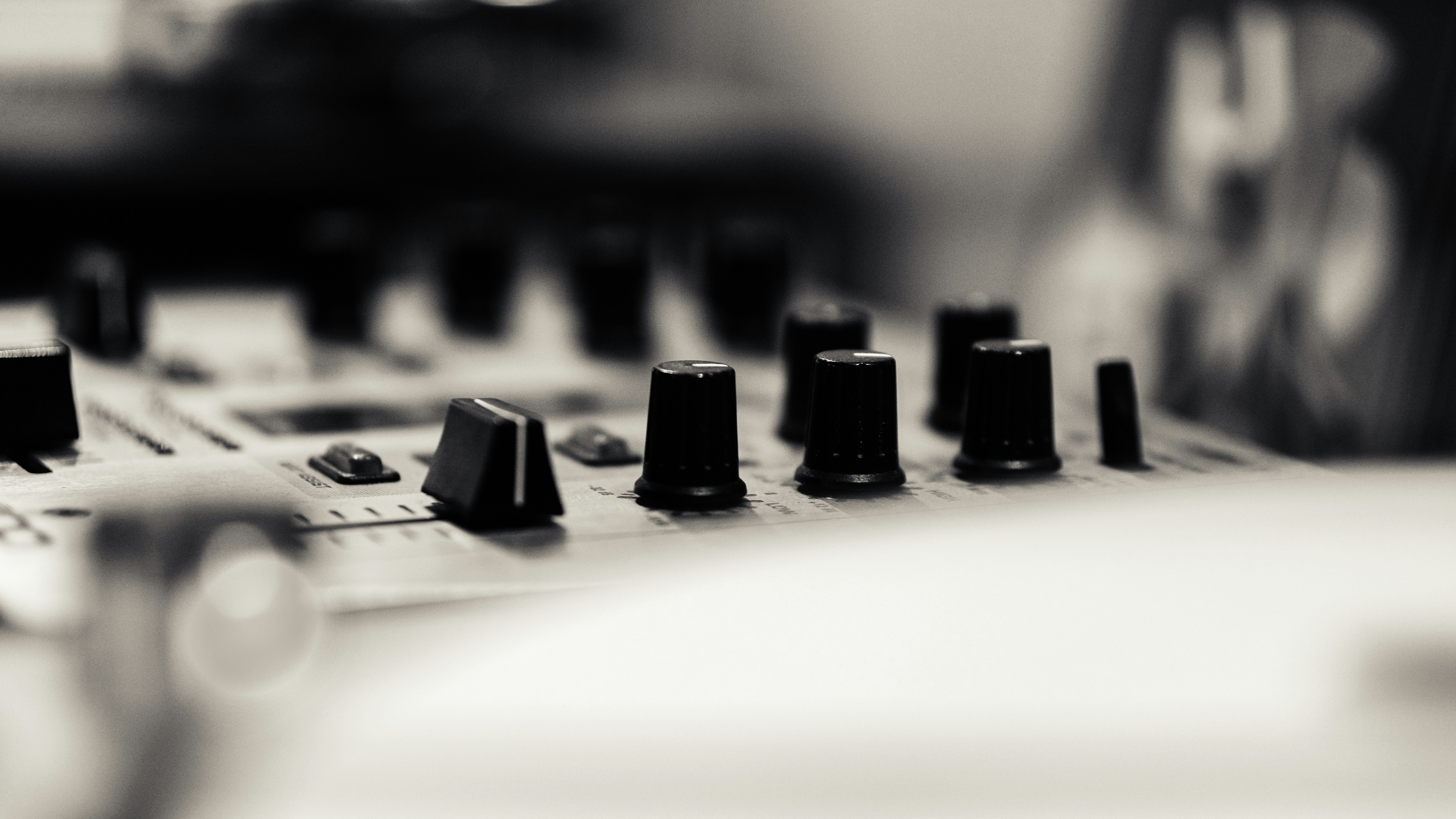 A close up of a sound board with many knobs