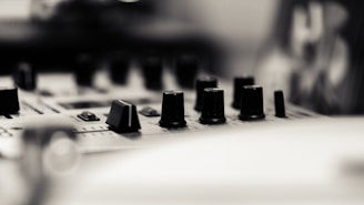 A close up of a sound board with many knobs