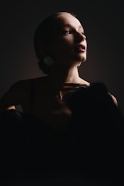 A woman in a dark room with a cat