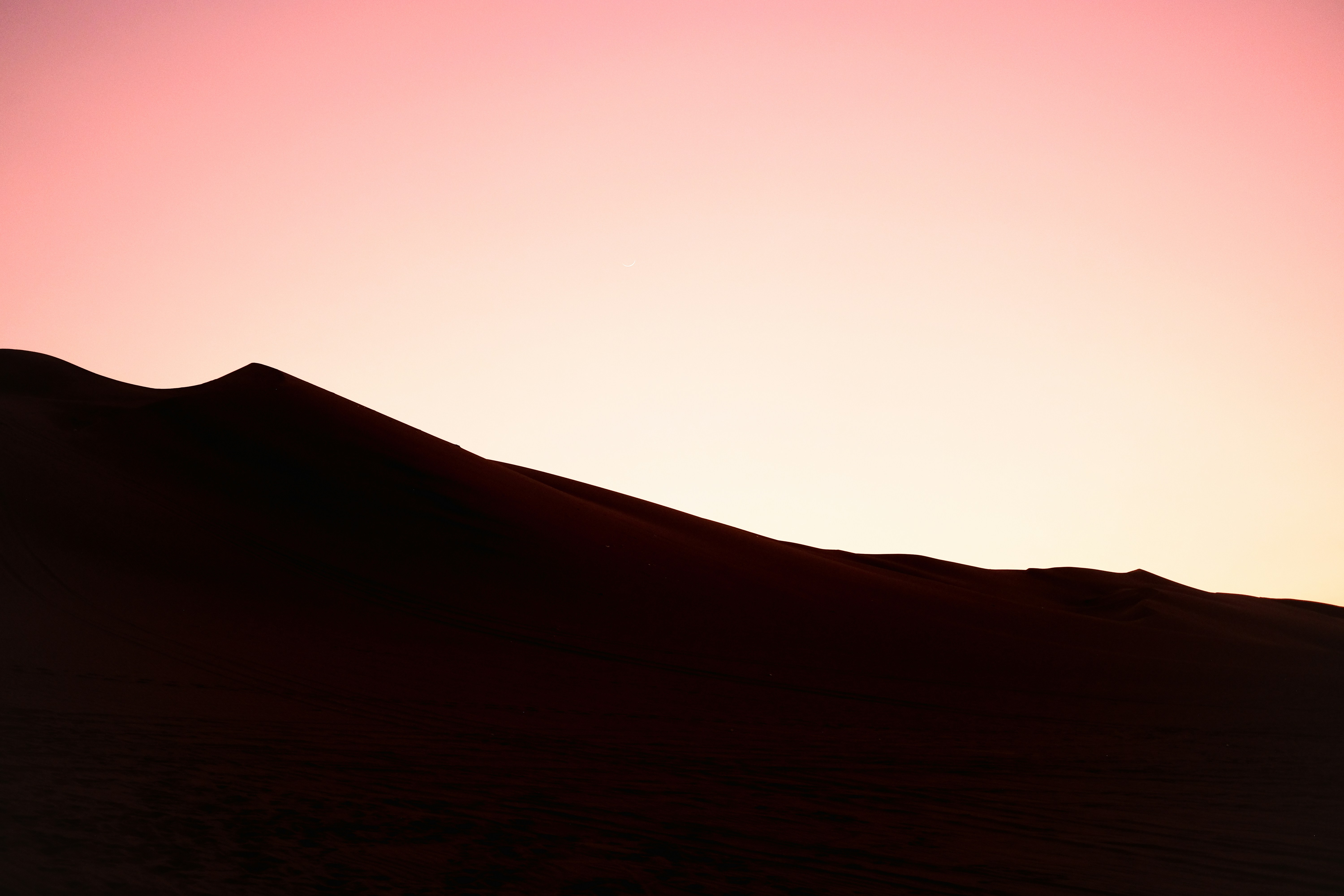 A silhouette of a person standing on top of a hill