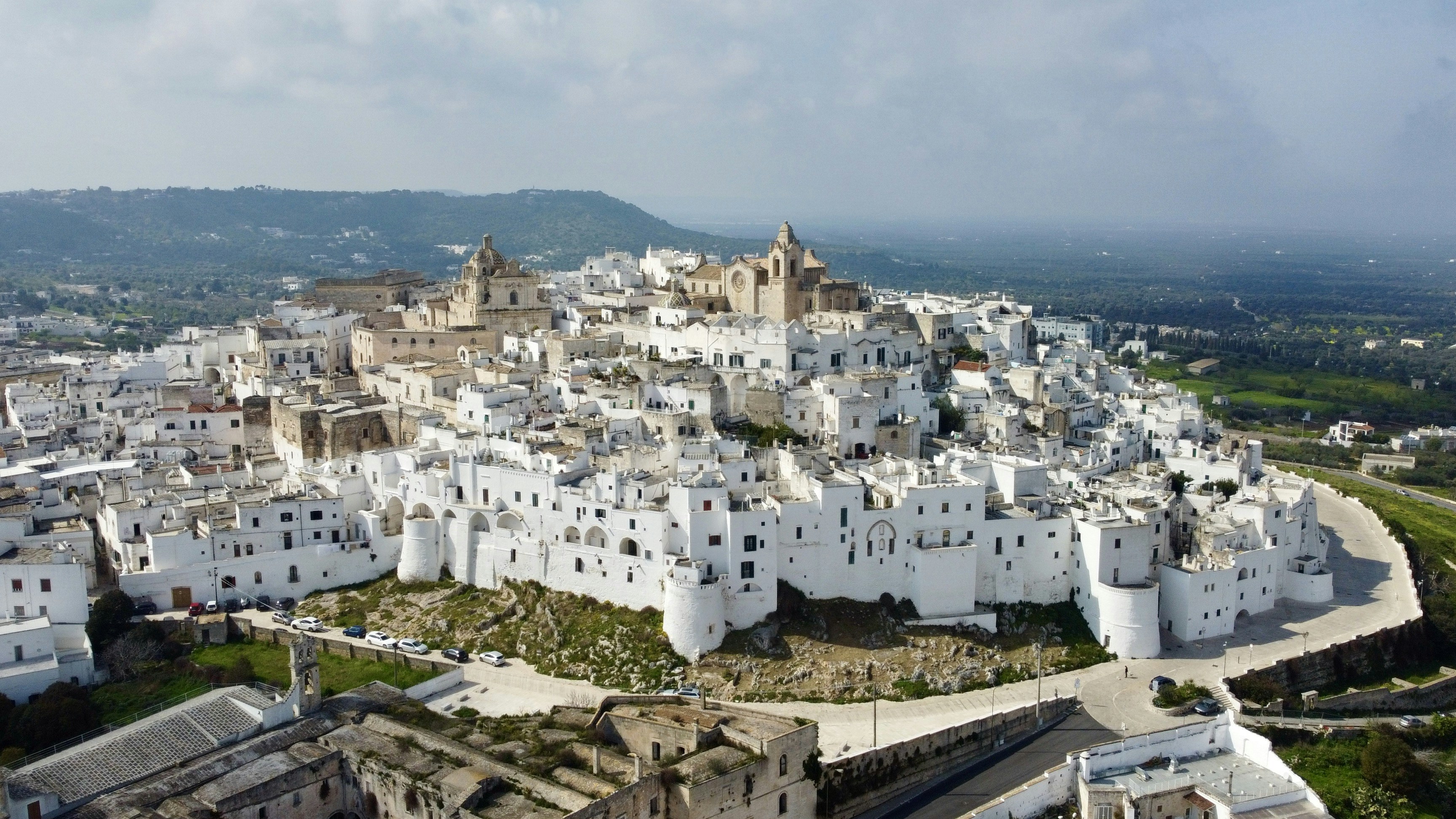 白い建物が立ち並ぶ街を上空から見る