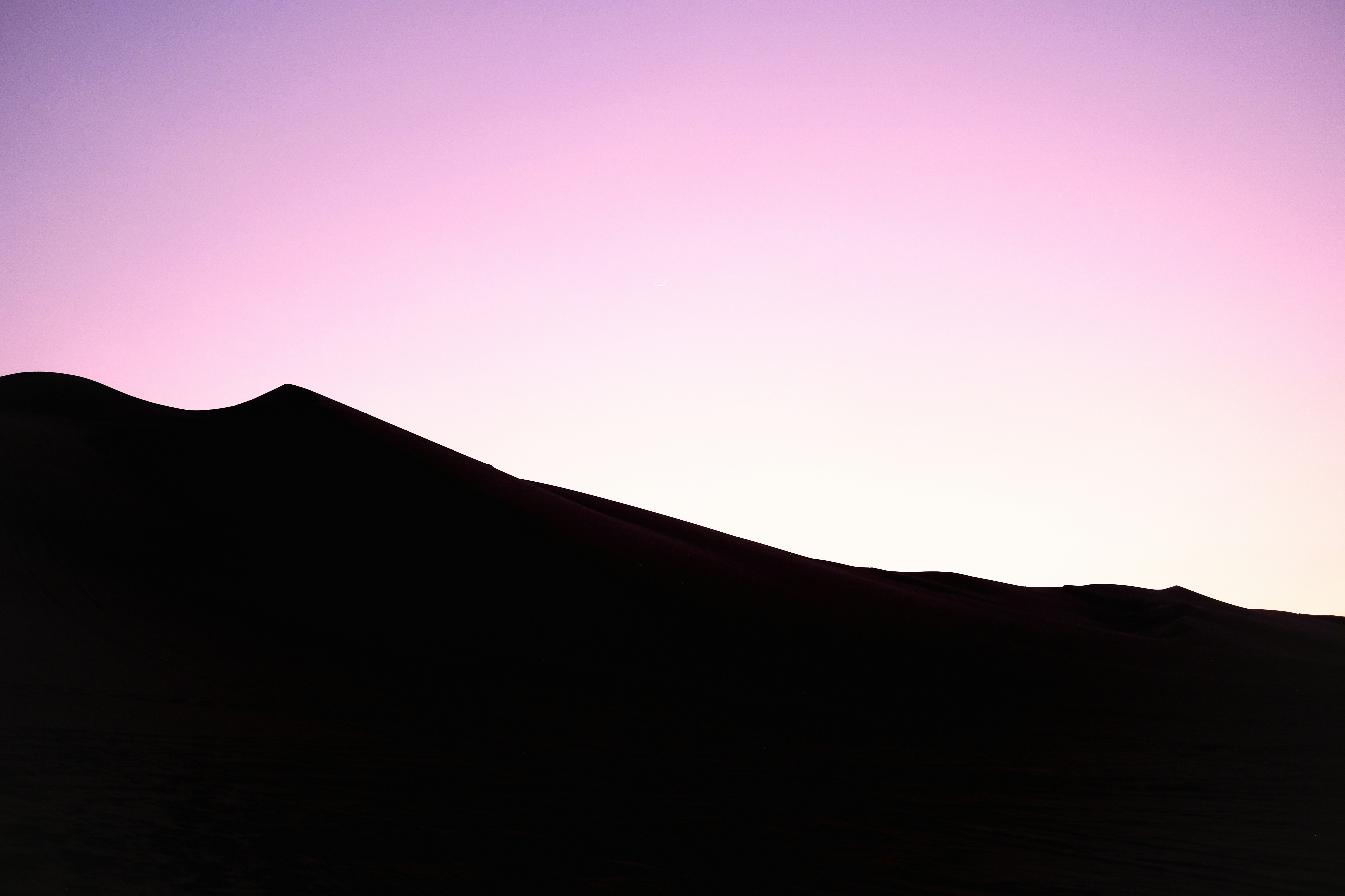 A silhouette of a person standing on top of a hill